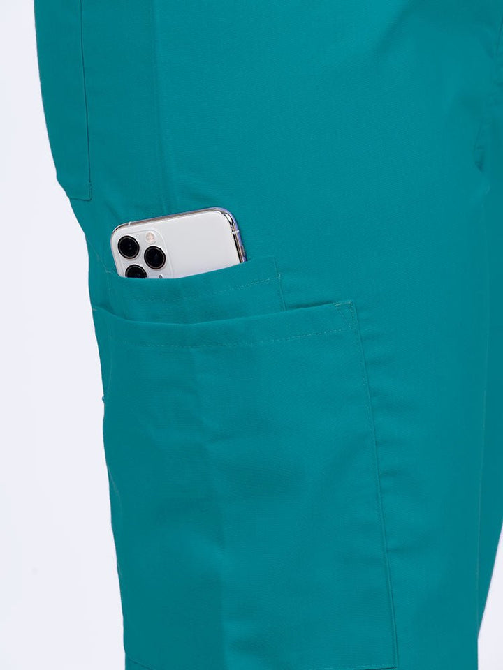 Female nurse wearing a Luv Scrubs Unisex Drawstring Cargo Pant in teal with 1 cargo & cell phone pocket on the wearer's right side.