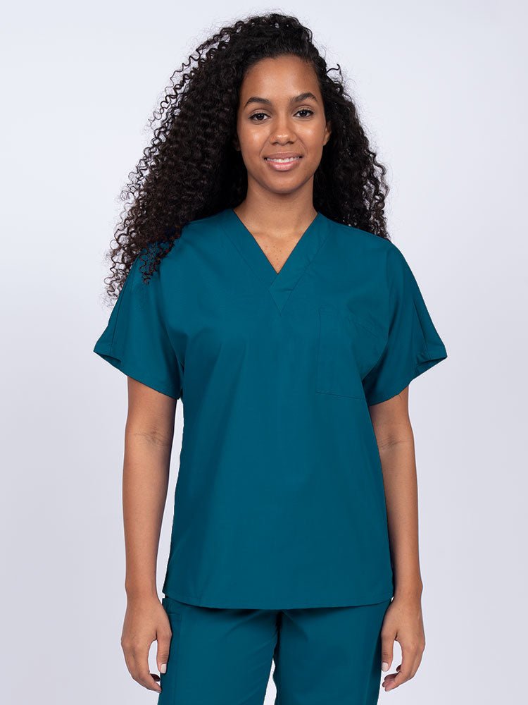 Young woman wearing a Luv Scrubs Unisex Single Pocket Scrub Top in Caribbean featuring a V-neckline.