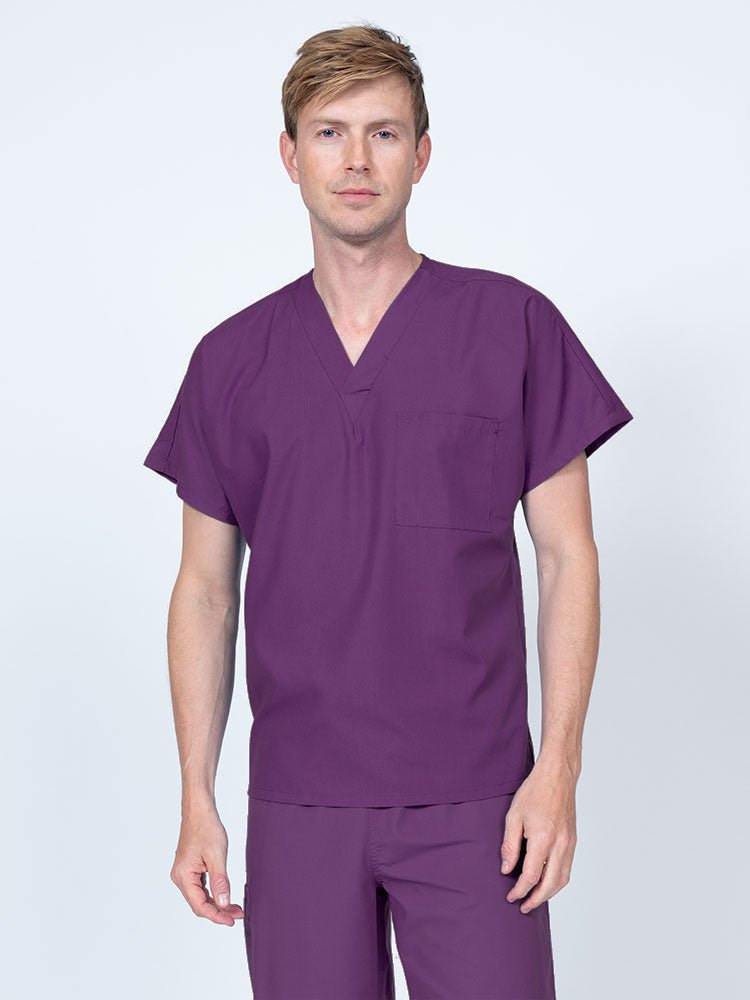 A young male Clinical Laboratory Technologist wearing a Luv Scrubs Unisex Single Pocket V-Neck Scrub Top in Eggplant with dolman sleeves and 1 chest pocket.
