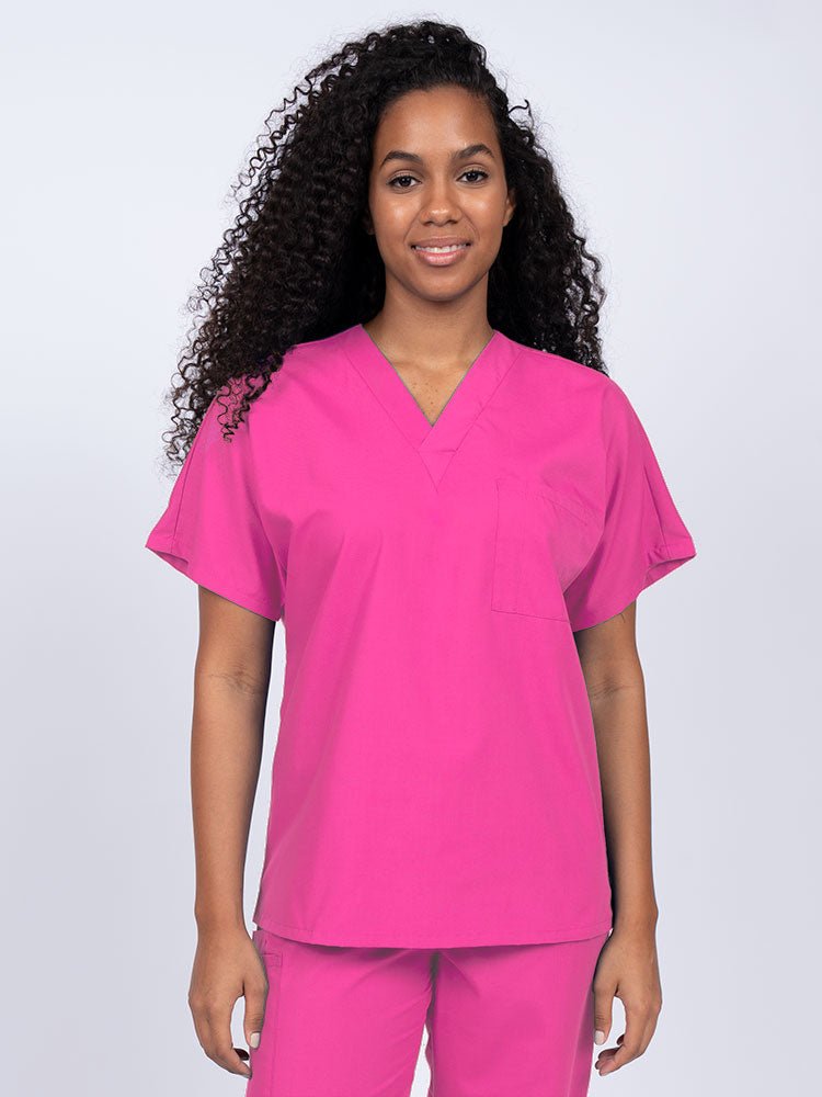 Young female Home Health Aide wearing a Luv Scrubs Unisex Single Pocket Scrub Top in shocking pink featuring a V-neckline.