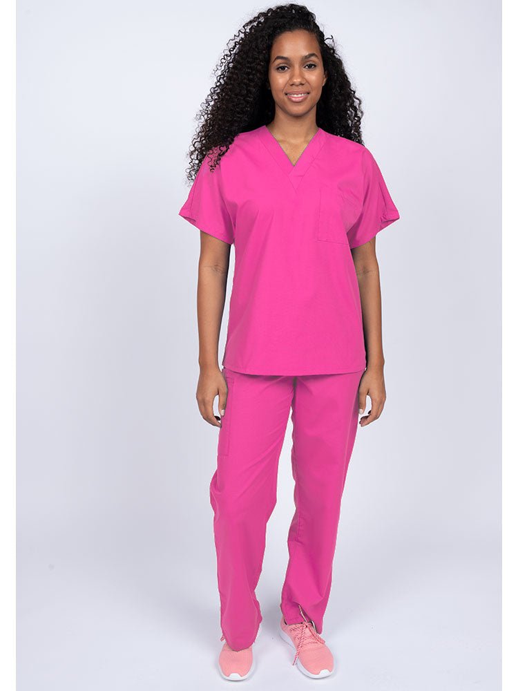 A young female Physical Therapist wearing a Luv Scrubs Unisex Single Pocket Scrub Top in shocking pink featuring a V-neckline.