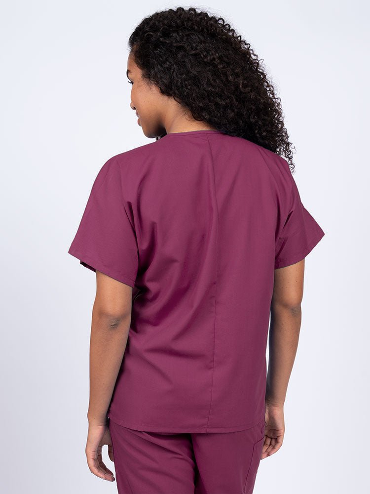 Nurse wearing a Luv Scrubs Unisex Single Pocket V-Neck Scrub Top in wine with a center back length of 27.5".