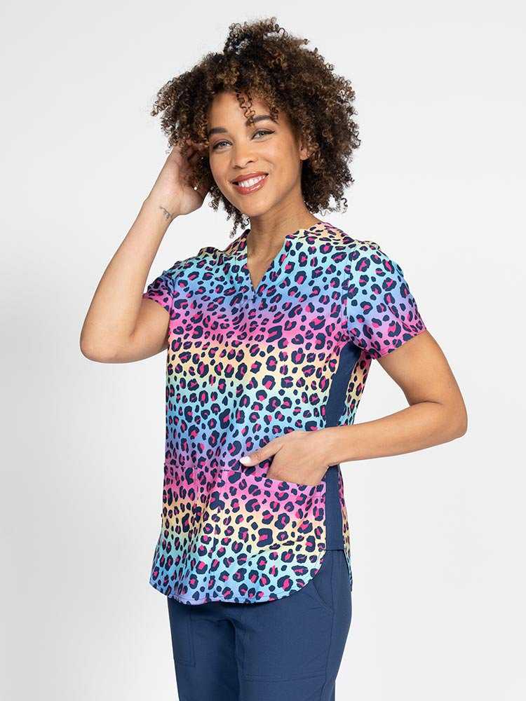 Young female Nurse Practitioner wearing a Meraki Sport Women's Print Scrub Top in "Animal Motion" featuring side slits for additional range of motion.