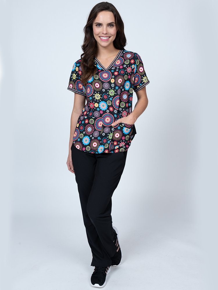 Young female nurse wearing a Meraki Sport Women's Print Scrub Top in "Cue N Cool" featuring side slits for additional range of motion.