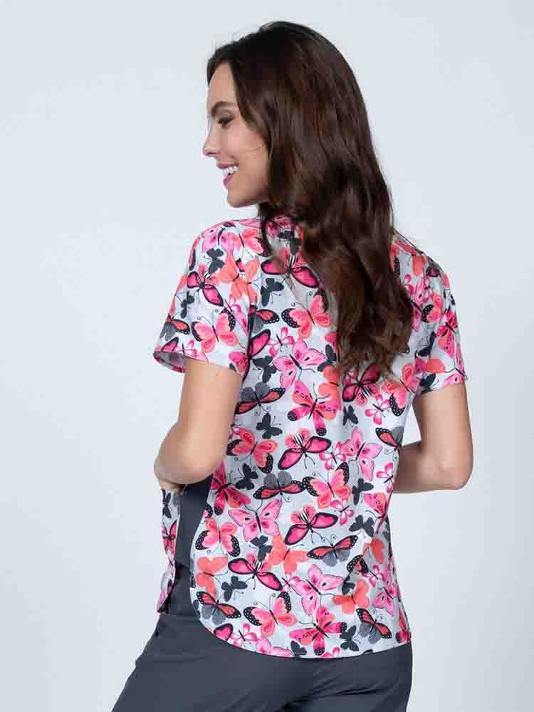 Young nurse wearing a Women's Print Scrub Top in "Enchanted Spirit" from Meraki Sport featuring shoulder yokes for a flattering fit.