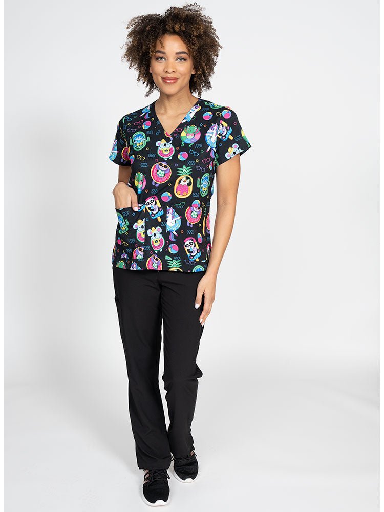 A female LPN wearing a Women's Print Scrub Top from Meraki Sport in "Pool Party" featuring 2 front patch pockets.