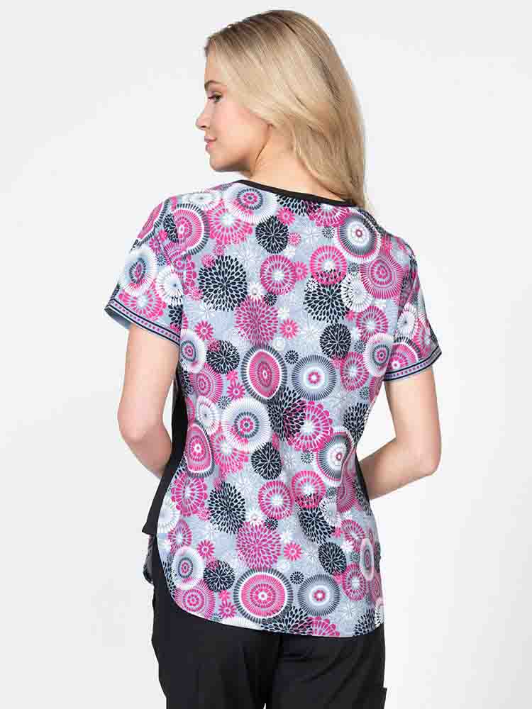 Young nurse wearing a Women's Print Scrub Top in "Raspberry Splash" from Meraki Sport featuring shoulder yokes for a flattering fit.