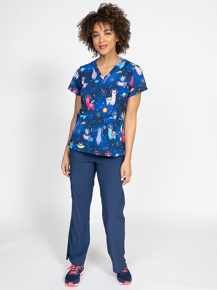 A female LPN wearing a Women's Print Scrub Top from Meraki Sport in "Space Llama" featuring 2 front patch pockets.