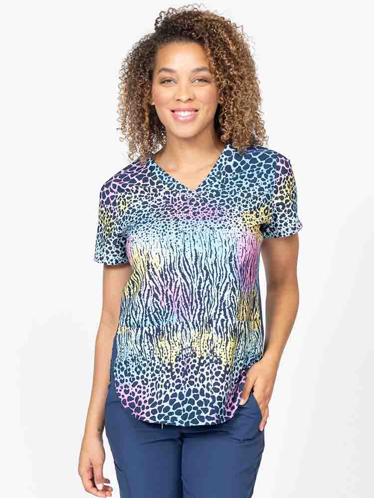 Young healthcare professional wearing a Meraki Sport Women's Print Scrub Top in "Trendy Spots" featuring stretch side panels for a comfortable all day fit.