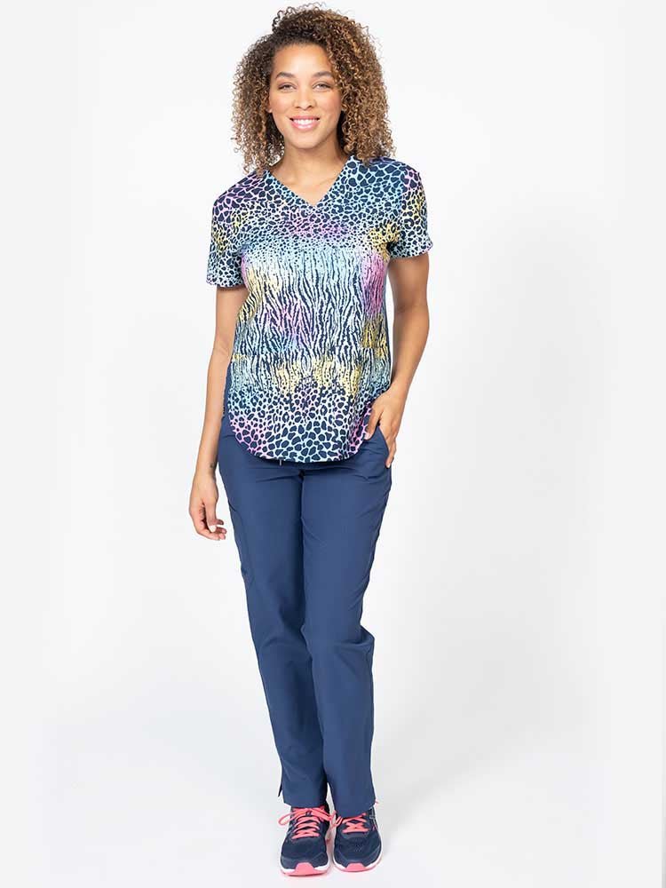 Young female nurse wearing a Meraki Sport Women's Print Scrub Top in "Trendy Spots" featuring side slits for additional range of motion.