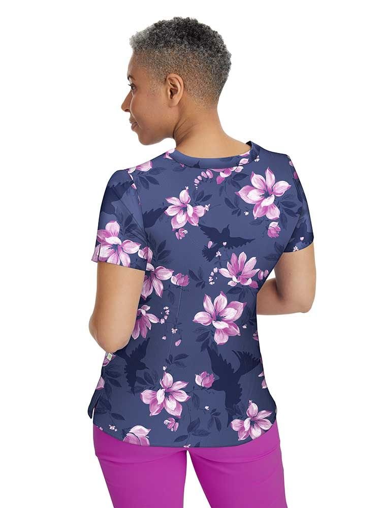 A middle aged female Psychiatric Nurse wearing a Women's Amanda Printed Scrub Top in "Nature Lover" size Medium featuring a center back length of 26.5".