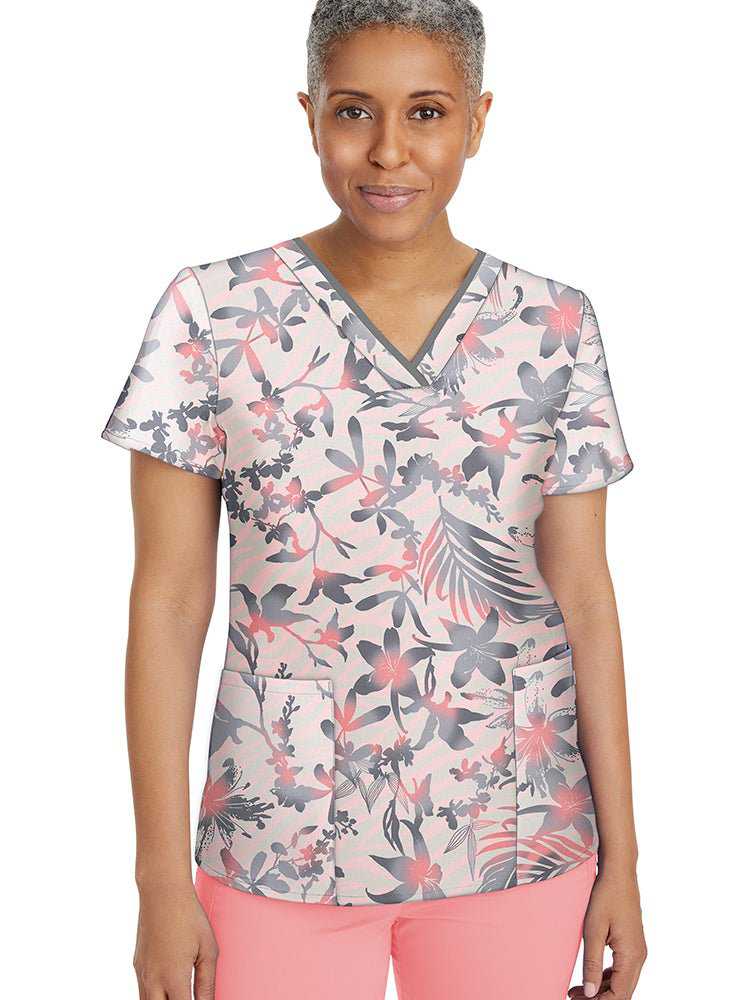 Young female healthcare worker wearing a Healing Hands Women's Amanda Print Top in "Surf's Up" featuring contrast binding and short sleeves with slit cuffs.