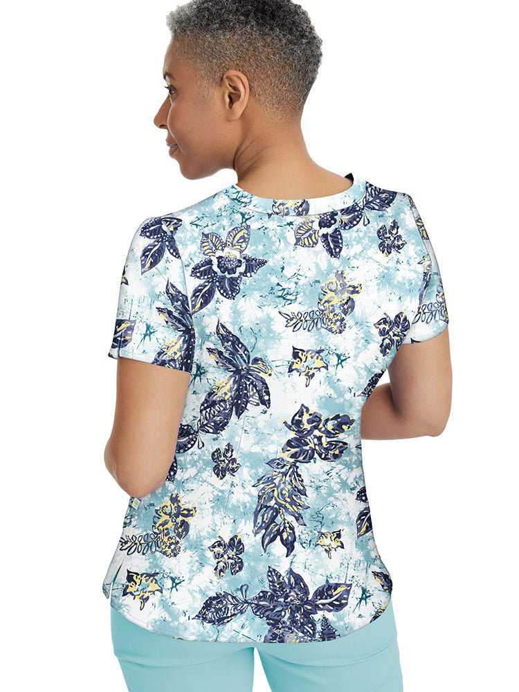 Young nurse wearing a Healing Hands Women's Amanda Print Top in "Tropical Tide" featuring back shaping darts & darts at the bust.