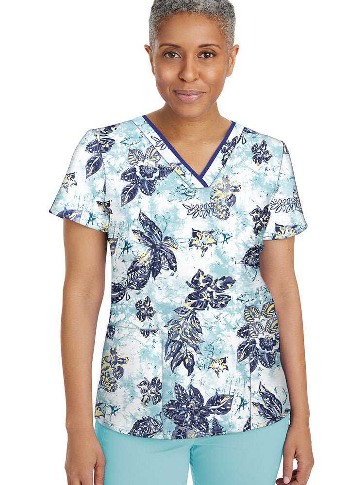Female healthcare worker wearing a Premiere by Healing Hands Women's Amanda Print Top in "Tropical Tide" featuring a v-neckline & a total of 3 pockets.