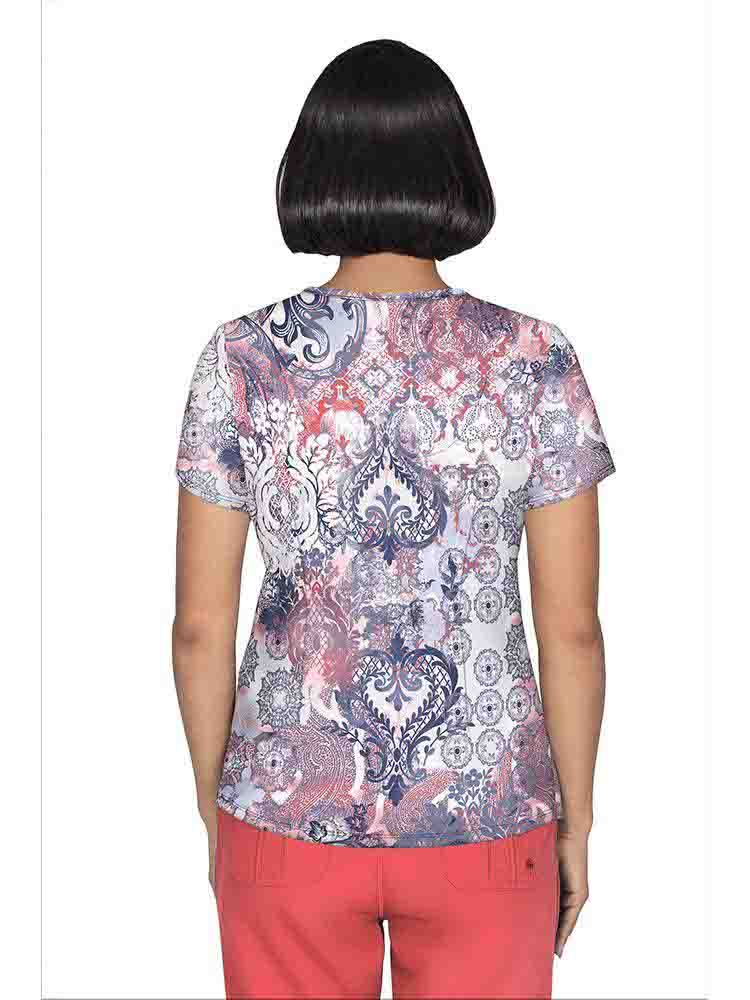 A young female Psychiatric Nurse wearing a Premiere by Healing Hands Y-neck Printed Scrub Top in "Antique Beauty" size Medium featuring a center back length of 26.5".