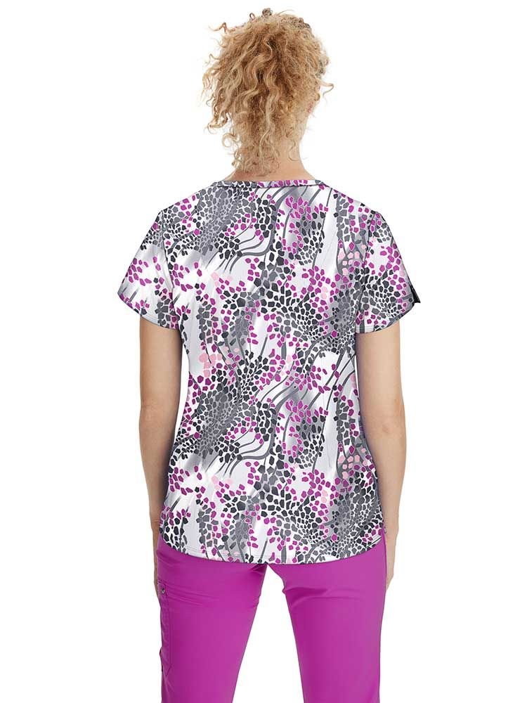 A female Psychiatric Nurse wearing a WOmen's Isabel Printed Scrub Top in "Modern Safari" size medium featuring back darts and a center back length of 26.5".