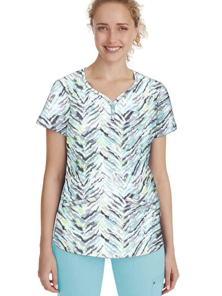 Female healthcare professional wearing a Healing Hands Women's Isabel Print Top in "Nature's Art" featuring 2 angled front pockets & side slits at the sleeves.