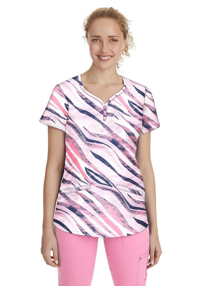 A young female Pediatric Nurse wearing a Women's Isabel Printed Scrub Top in "Wild Stripes" featuring a y-neckline and short sleeves.