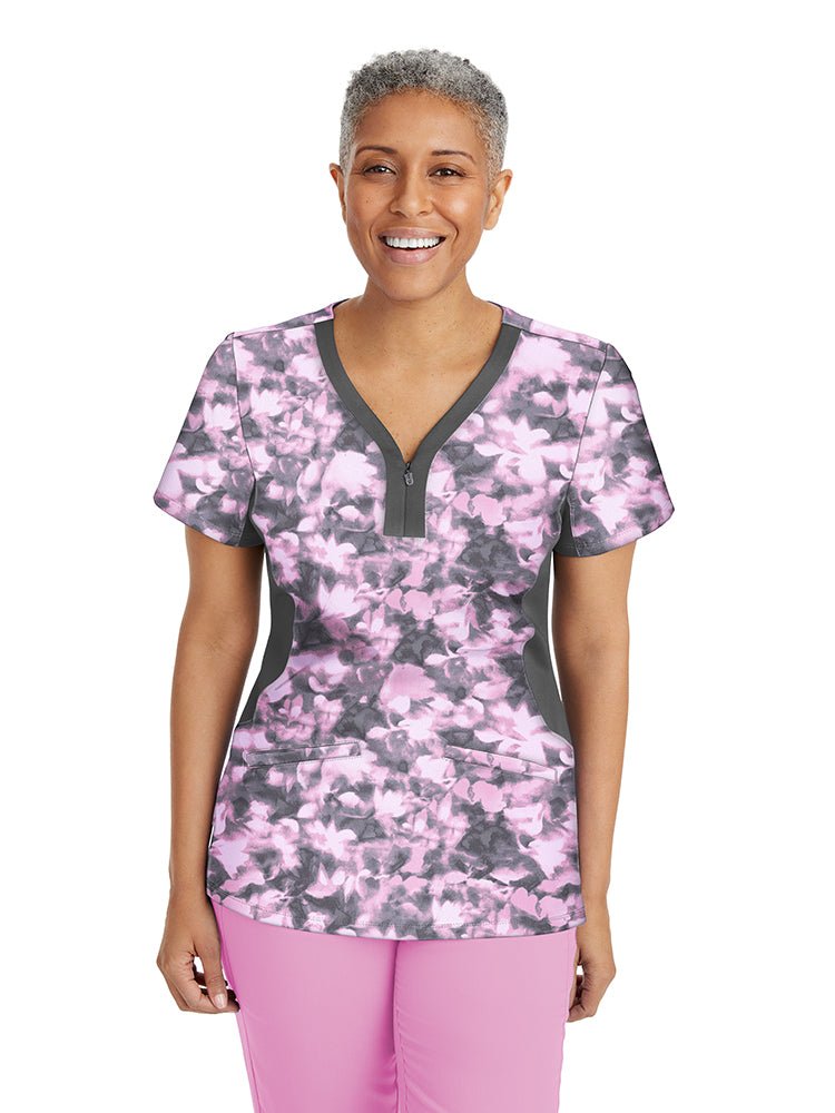 Young nurse wearing a Premiere by Healing Hands Women's Jessi Print Top in "Abstract Bliss" featuring 2 Front patch pockets & side vents at the hemline.