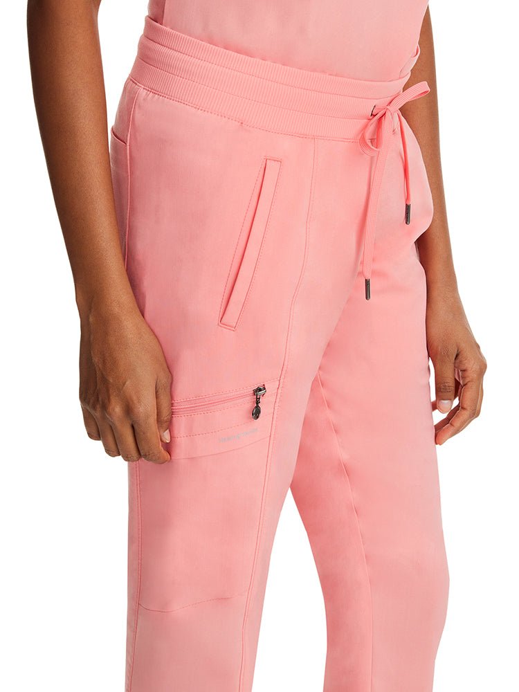 Female nurse wearing a pair of Purple Label by Healing Hands Women's Toby Joggers in "Melon" featuring 1 zippered cargo pocket on the wearer's right side.