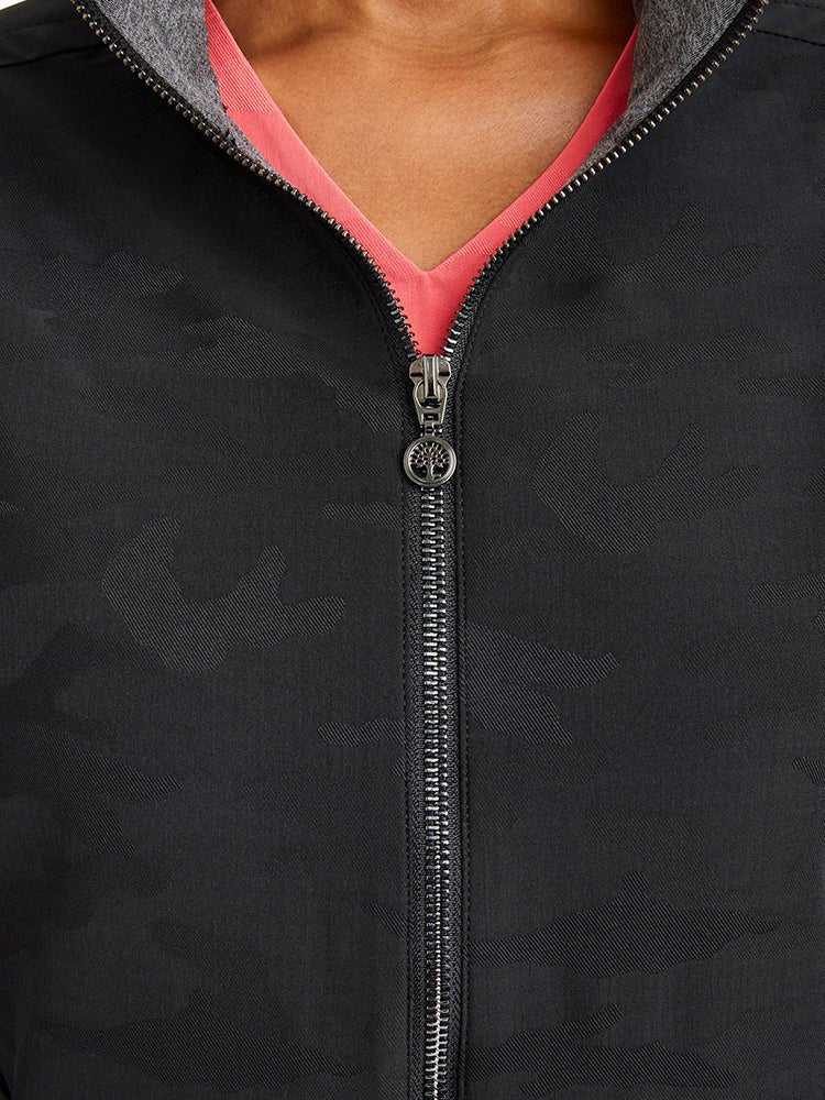 A close up view of the neckline of the Purple Label Women's Destini Camo Scrub Jacket in Black size large.
