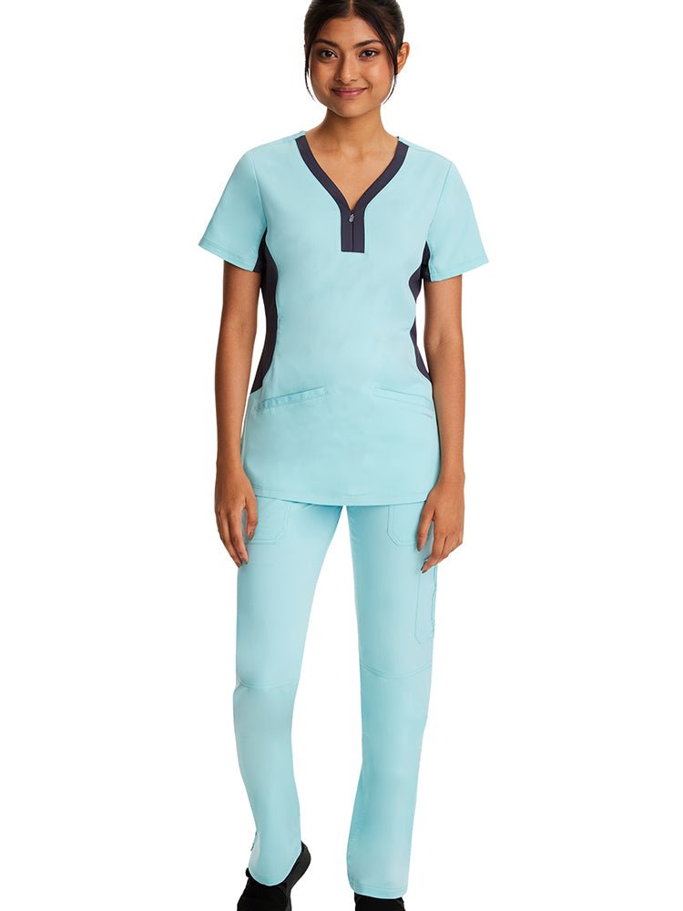 Female RN wearing a Purple Label Women's Jessi Y-neck Scrub Top in "Seabrook" featuring a logo placket at the wearer's right pocket side.