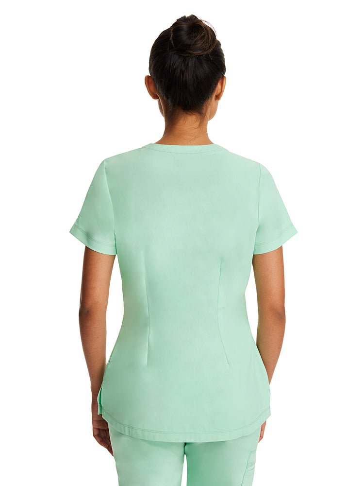 Young female healthcare professional wearing a Purple Label Women's Jill V-Neck Scrub Top in Cool Mint with 2 front patch pockets. 