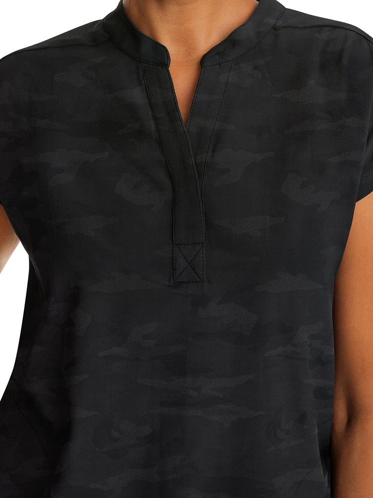 A young female Home Care Health Aide wearing a Purple Label Women's Journey Camo Top in Black sixe 2XL featuring a Mandarin one button collar.