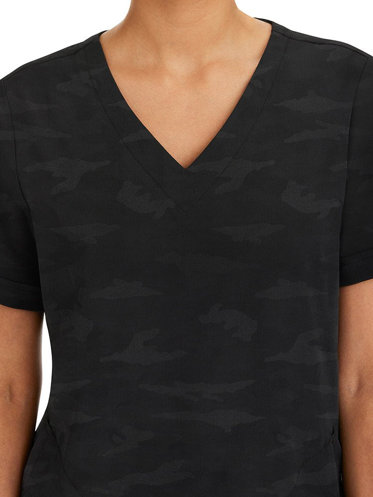 Female healthcare professional wearing a Purple Label Women's Joy Camo Top in black featuring a unique Jacquard 4-Way Stretch Fabric.