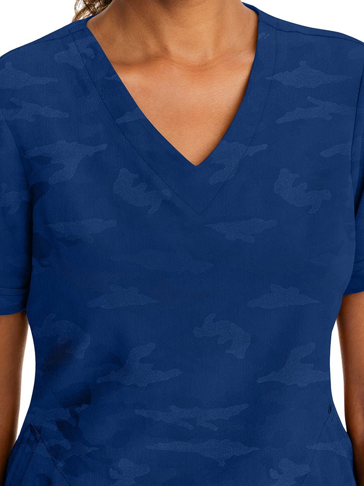 Female healthcare professional wearing a Purple Label Women's Joy Camo Top in Navy featuring a unique Jacquard 4-Way Stretch Fabric.