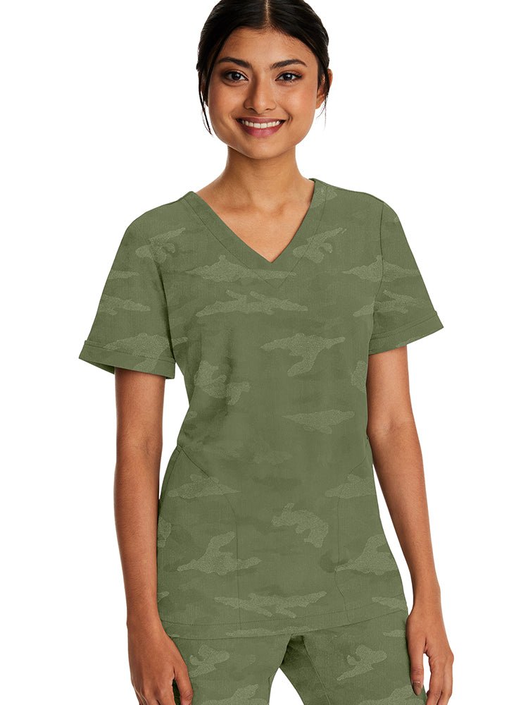 Young woman wearing a Purple Label Women's Joy Camo Top in Olive featuring a v-neckline.