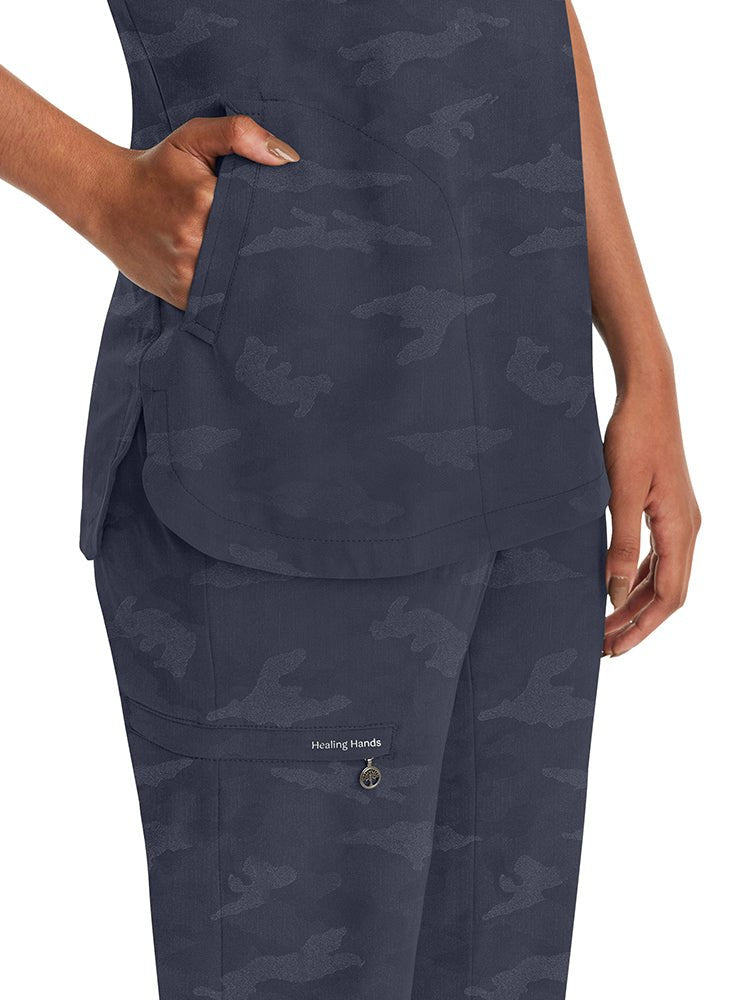 Young nurse wearing a Purple Label Women's Joy Camo Top in Pewter with 2 welt pockets on each side.