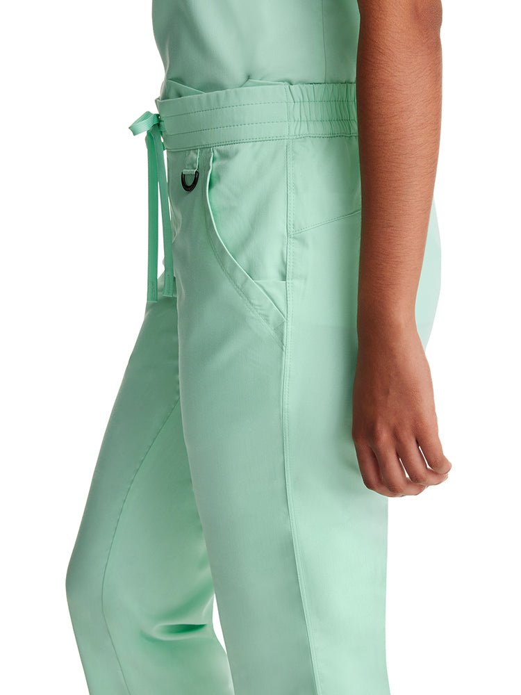 Young woman wearing a pair of Purple Label Women's Tamara Cargo Scrub Pants in "Cool Mint" with a metal D-ring at the waist.