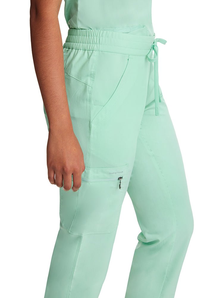 Young nurse wearing a pair of Purple Label Women's Tamara Cargo Scrub Pants in "Cool Mint" with a triple cargo pocket no the wearer's right side.