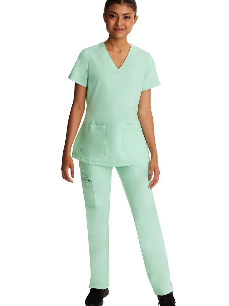 Young woman wearing a pair of Purple Label Women's Tamara Cargo Scrub Pants in "Cool Mint" with 2 front slash pockets.