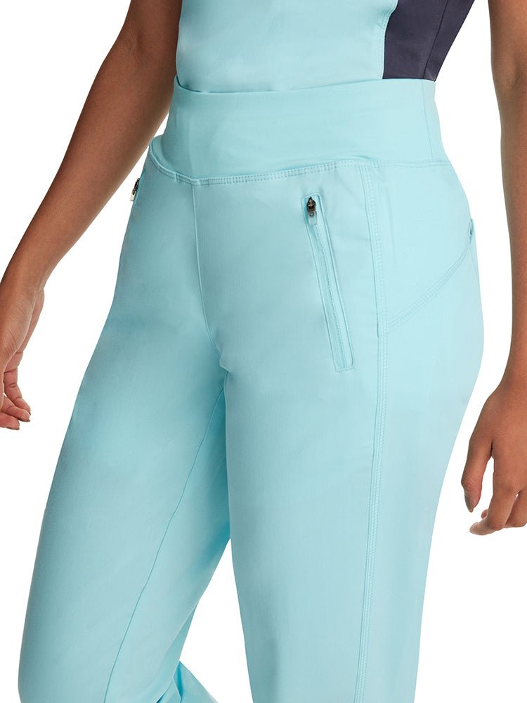Female healthcare worker wearing a pair of Purple Label Women's Tara Jogger Scrub Pants in "Seabrook" featuring 2 front "invisible" zip closure pockets.