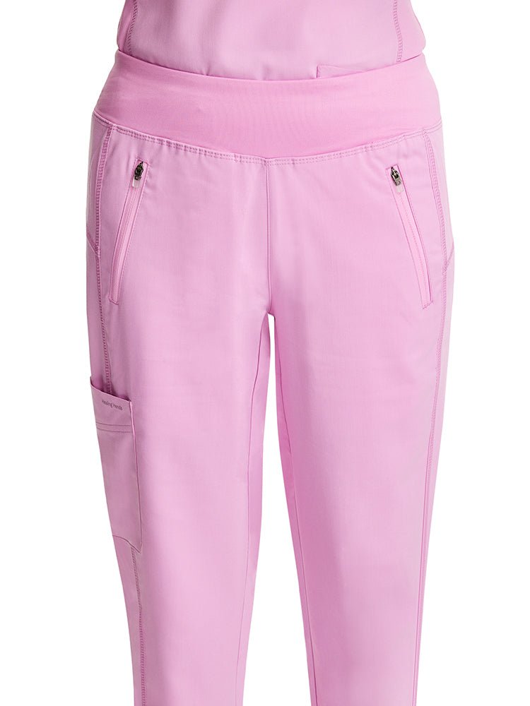 Nurse wearing a pair of Purple Label Women's Tara Jogger Scrub Pants in Taffy Pink featuring 2 front invisible zip closure pockets. 