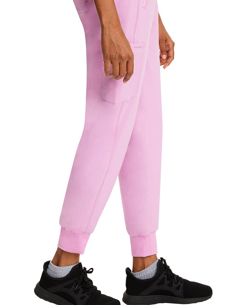 Young woman wearing a pair of Purple Label Women's Tara Jogger Scrub Pants in Taffy Pink featuring a unique stretch poplin fabric designed to  move with your body all day.