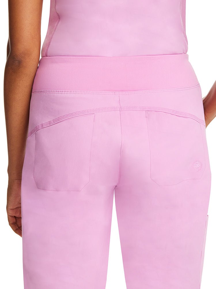 Young woman wearing a pair of Purple Label Women's Tara Jogger Scrub Pants in Taffy Pink featuring 2 back patch pockets with trim details.