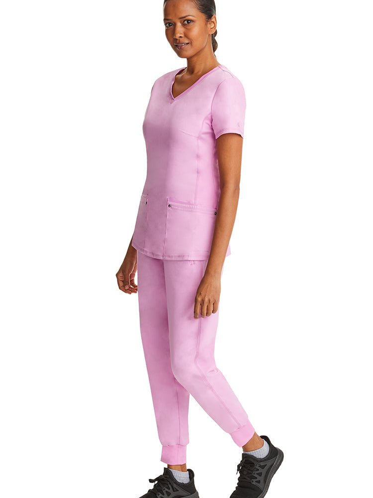 Female nurse practitioner wearing a pair of  Purple Label Women's Tara Jogger Scrub Pants in Taffy Pink featuring a rib knit trim at the hemline.