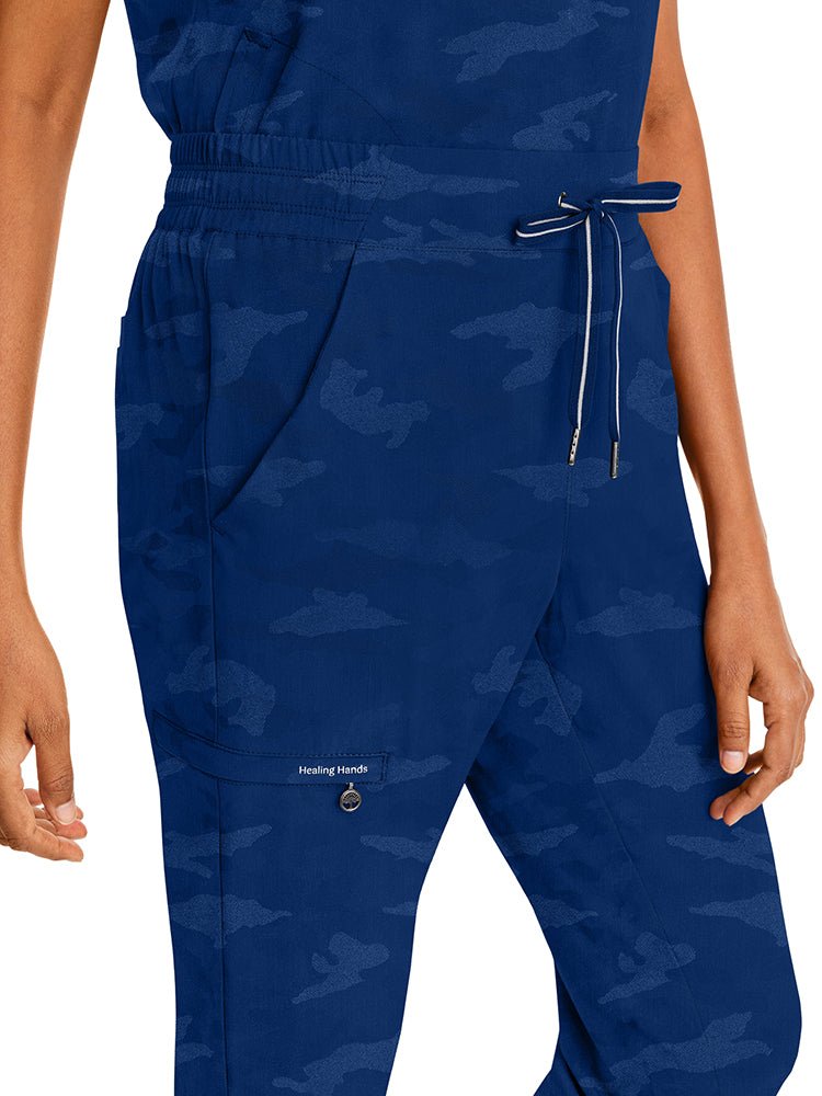 Young nurse wearing a pair of Purple Label Women's Tate Camo Joggers in Navy featuring a total of 5 pockets.