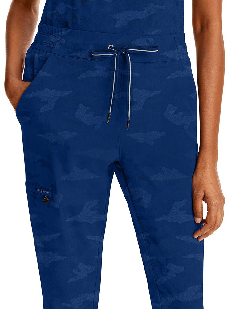 Young woman wearing a pair of Purple Label Women's Tate Camo Joggers in Navy featuring a "Gun Metal" tip with contrast stripe & grommets.