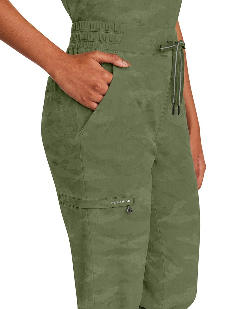 Female healthcare worker wearing a pair of Purple Label Women's Tate Camo Joggers in Olive with back elastic & a flat front.