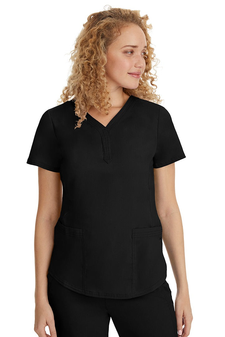 A young female healthcare professional wearing a Purple Label Women's Jane V-Neck Scrub Top in Black featuring 2 front patch pockets.
