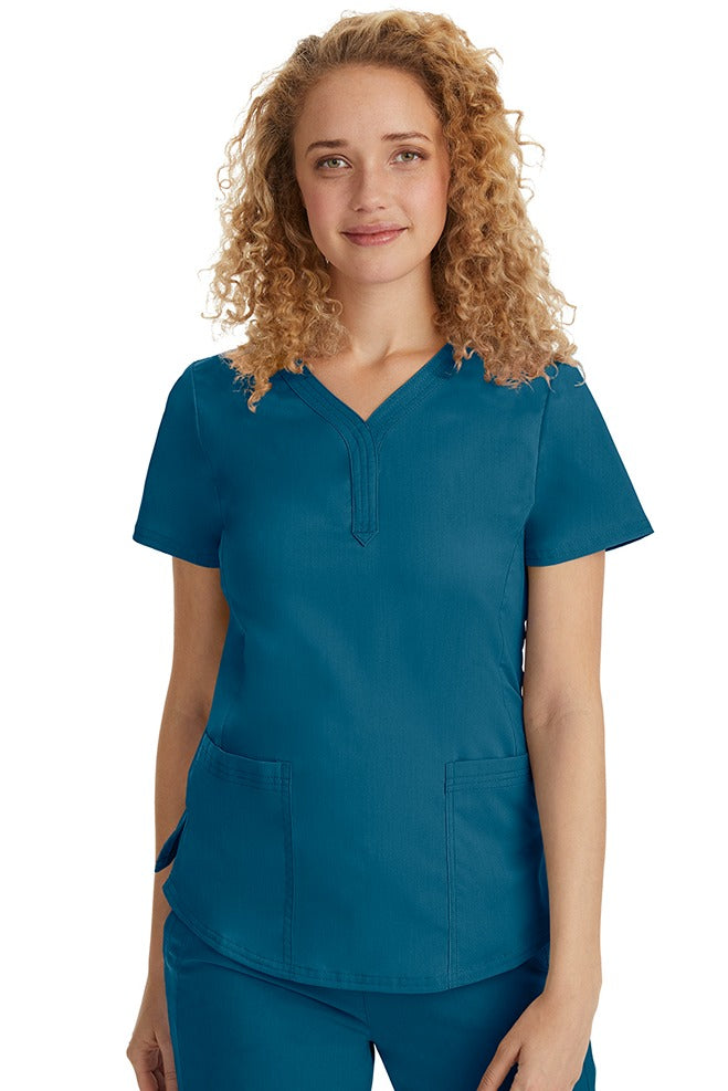 A female Emergency Room Registered Nurse wearing a Purple Label Women's Jane V-Neck Scrub Top in Caribbean featuring front seams for a flattering a fit.