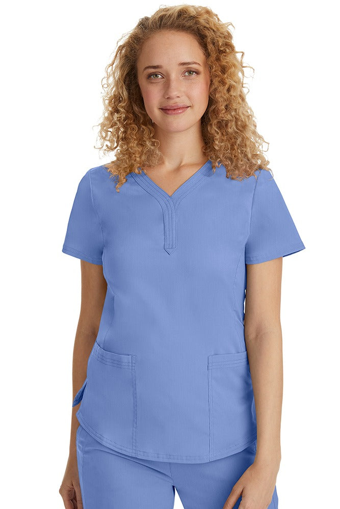 A female Emergency Room Registered Nurse wearing a Purple Label Women's Jane V-Neck Scrub Top in Ceil featuring front seams for a flattering a fit.