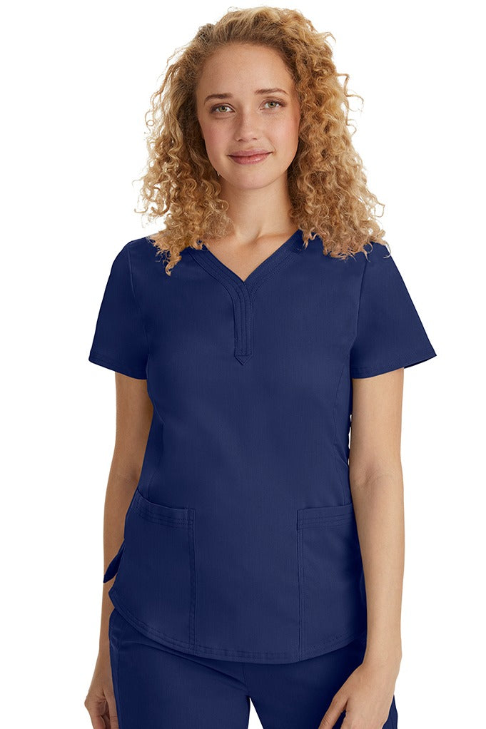 A female Emergency Room Registered Nurse wearing a Purple Label Women's Jane V-Neck Scrub Top in Navy featuring front seams for a flattering a fit.