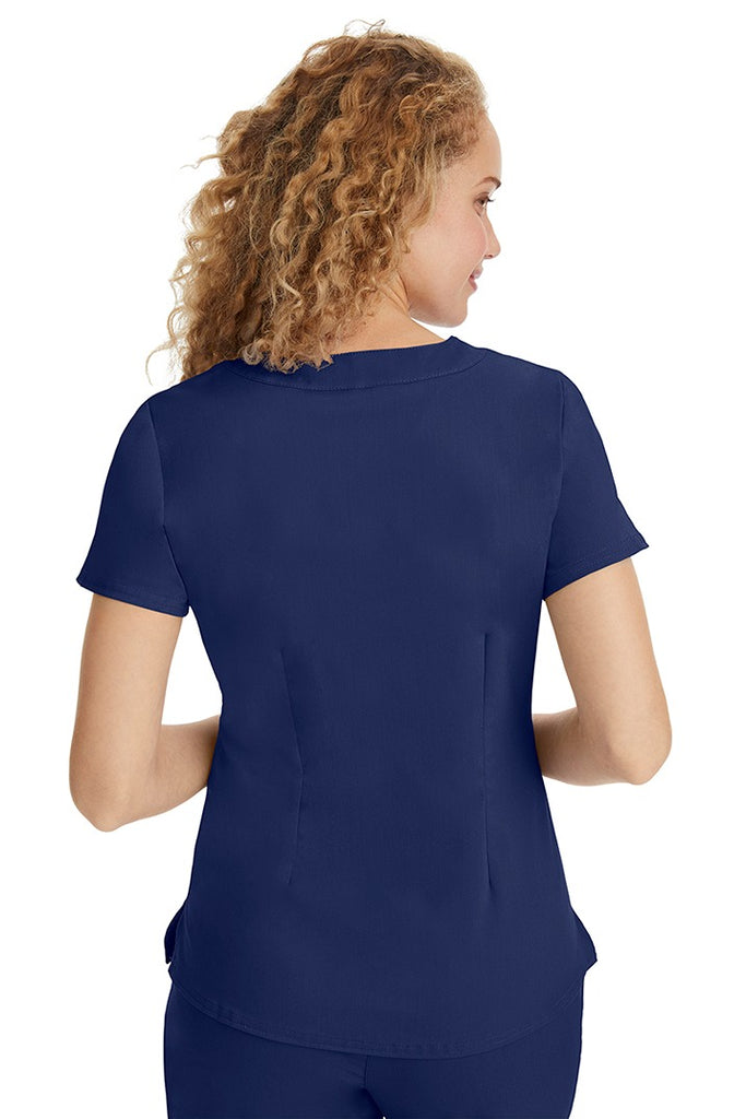 A young LPN wearing a Purple Label Women's Jane V-Neck Scrub Top in Navy featuring a medium center back length of 26.5".
