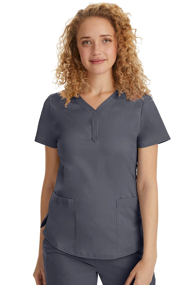A female Emergency Room Registered Nurse wearing a Purple Label Women's Jane V-Neck Scrub Top in Pewter featuring front seams for a flattering a fit.