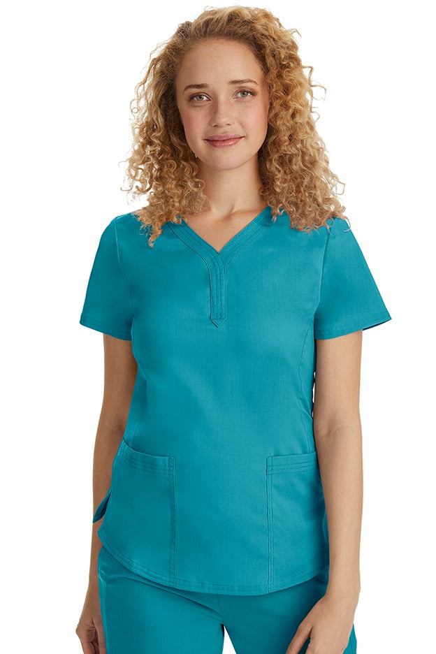 A female Emergency Room Registered Nurse wearing a Purple Label Women's Jane V-Neck Scrub Top in Teal featuring front seams for a flattering a fit.